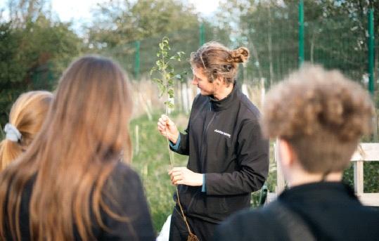 staff member at Garon Park teaching volunteers outdoors